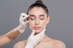 Cosmetologist Examining Facial Wrinkles on Young Woman Face